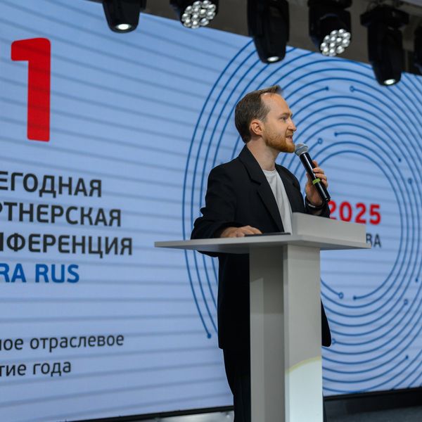 Выступление на сцене на фоне экрана конференции
