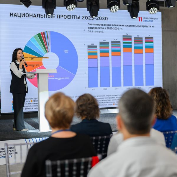 Спикер у экрана с диаграммами